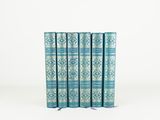 a set of four blue books sitting on top of each other