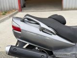 a silver motorcycle parked in front of a garage