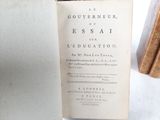 a book that is open on a table next to a stack of books