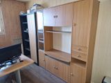 a desk with a computer and a cabinet in the room