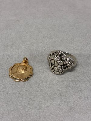 two silver and gold rings sitting on top of a white surface