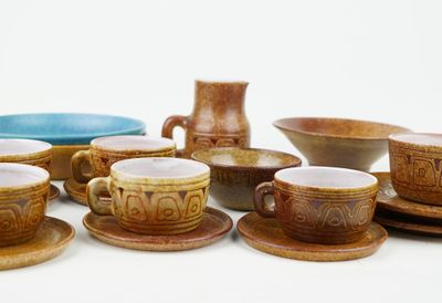 many cups and saucers sitting on a table