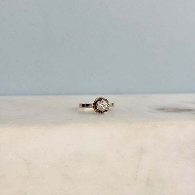 une photo d'une bague en diamant posée sur une table en marbre
