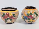 deux vases avec des fleurs peintes sur une surface blanche