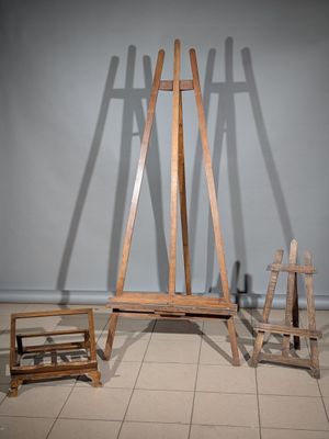 un chevalet en bois posé par terre à côté d'une chaise en bois