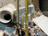 a large pile of trash in a warehouse with a machine