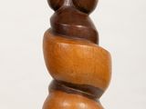 a wooden sculpture of a bear sitting on top of a stack of rocks