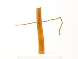 a wooden cross on a white pedestal with a rope