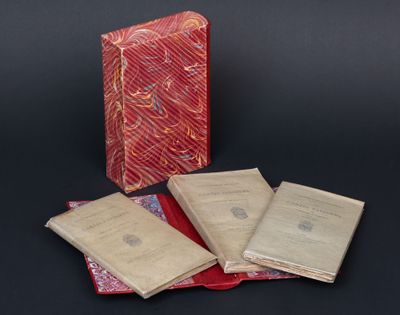trois livres sont empilés les uns sur les autres sur une surface noire