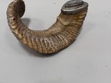 un objet en forme de corne surmonté d'une montre