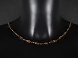 un gros plan sur le torse d'un mannequin portant un collier à chaîne en or