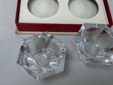 two glass ashtrays in a red box on a table