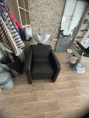 a black chair in a room with a mirror on the wall