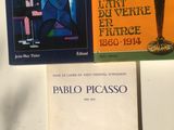 trois livres posés sur une table, à côté d'une lampe