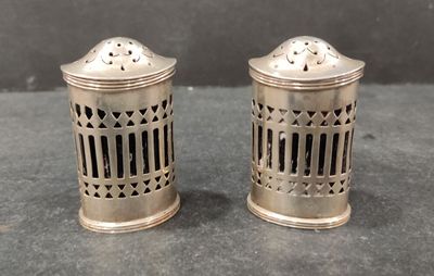pair of silver salt and pepper shakers on a table