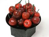 a bowl of cherries on a white surface