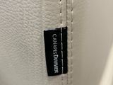 a close up of a white bag with a black label on it