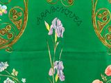 an image of a green table cloth with a picture of a vase of flowers