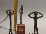 three bronze figurines of a man and a woman standing on a skateboard