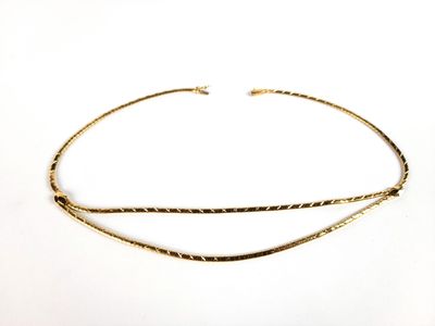un gros plan d'un collier ras-du-cou en or sur fond blanc