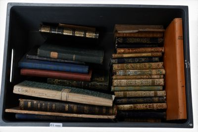 une boîte noire remplie de nombreux livres, posée sur une table