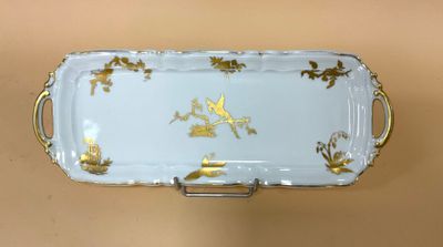 un plateau blanc et doré orné de fleurs dorées