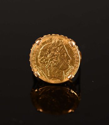 a gold sovereign coin on a black surface