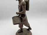 bronze figurine of a man with a bag and a cigarette