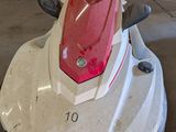 a red and white jet ski parked in a garage