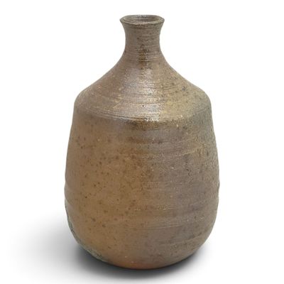 a brown vase that is sitting on a white surface