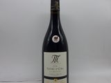 une bouteille de vin rouge posée sur une table blanche