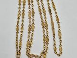 a gold chain with a clasp and a tag on it