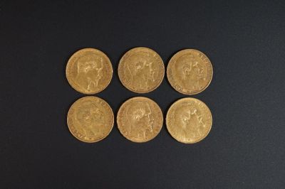 quatre pièces d'or sont disposées en ligne sur une surface noire