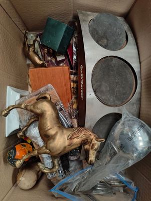 a cardboard box filled with assorted items and a horse statue