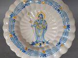 une assiette bleue et blanche avec une image de femme dessus