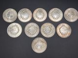 six silver coins are arranged in a triangle on a black surface