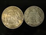 two silver coins, one of which is a woman and one of which is a man
