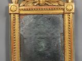 un miroir avec un cadre doré sur fond gris