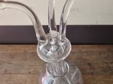 a clear glass vase with a flower in it on a wooden table