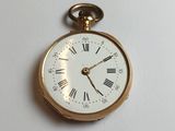 une montre de poche en or avec des chiffres romains