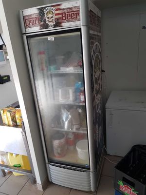 a refrigerator in the corner of a kitchen with a lot of food in it