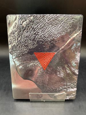 une image montrant un gros plan d'un objet métallique sur lequel figure un triangle rouge