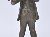 bronze statue of a man playing a flute on a rock