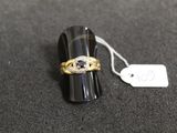 a close up of a ring on a black surface with a price tag