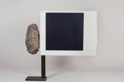 a rock on a stand with a picture frame on it