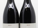 deux bouteilles de vin rouge posées l'une à côté de l'autre sur une surface blanche
