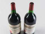 two bottles of red wine sitting next to each other on a white surface
