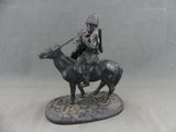 a statue of a man riding a horse with a dog