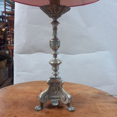 une lampe posée sur une table, avec un abat-jour rose