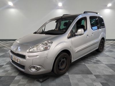 une photo d'une petite camionnette argentée garée dans un garage